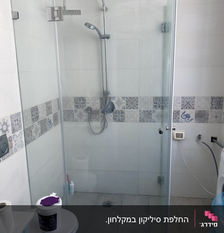 מקלחון זכוכית עם ראש מקלחת מתכתי וקיר אריחים מעוצב